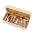 A beige box holds 8 cat toys: two feather wands, two mouse toys, two striped cylinders, a woven ball, and a woven circular toy.