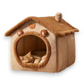 Soft beige and brown plush house-shaped pet bed featuring a circular entrance, a chimney, bear-ear details, and a small sleeping ginger cat.